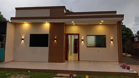Fachada texturada en beige con volumen símil madera e iluminación cálida, foto publicada por una clienta en Google